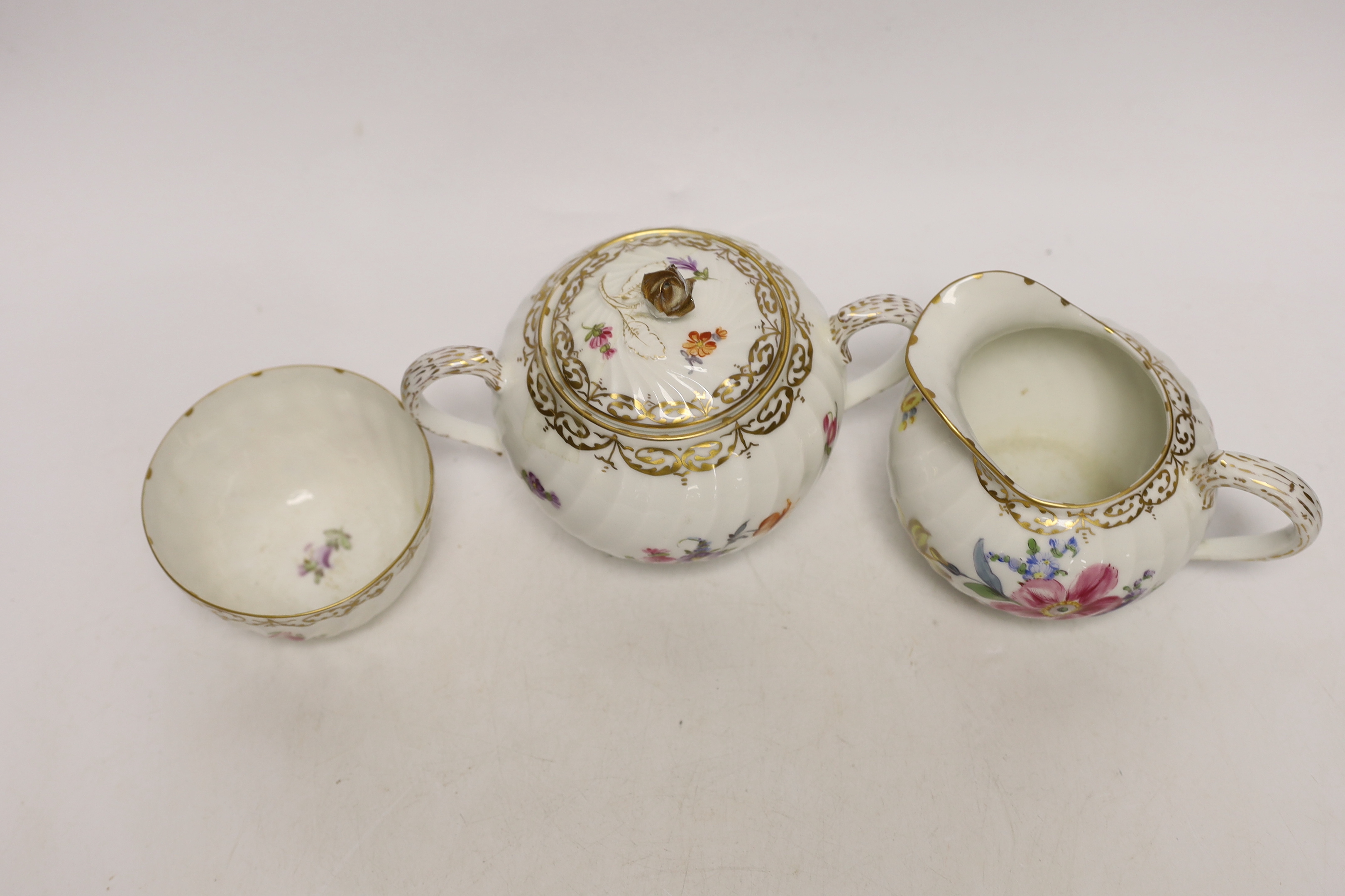 A Nymphenburg floral decorated teapot, milk jug and sugar bowl, teapot 13c high